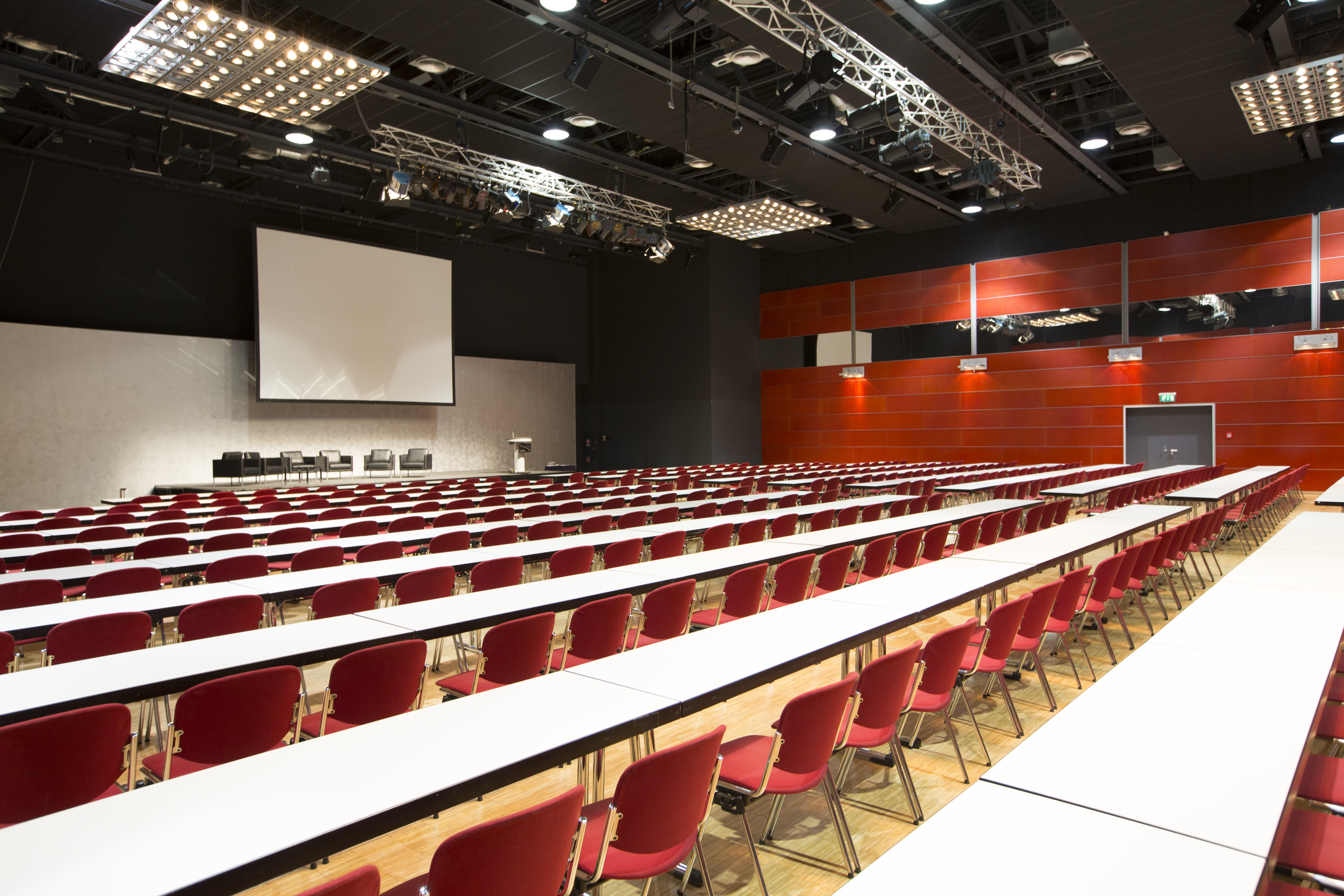 Parlamentarisch bestuhlter Congress Saal des RuhrCongress Bochum mit Blick zur Leinwand.